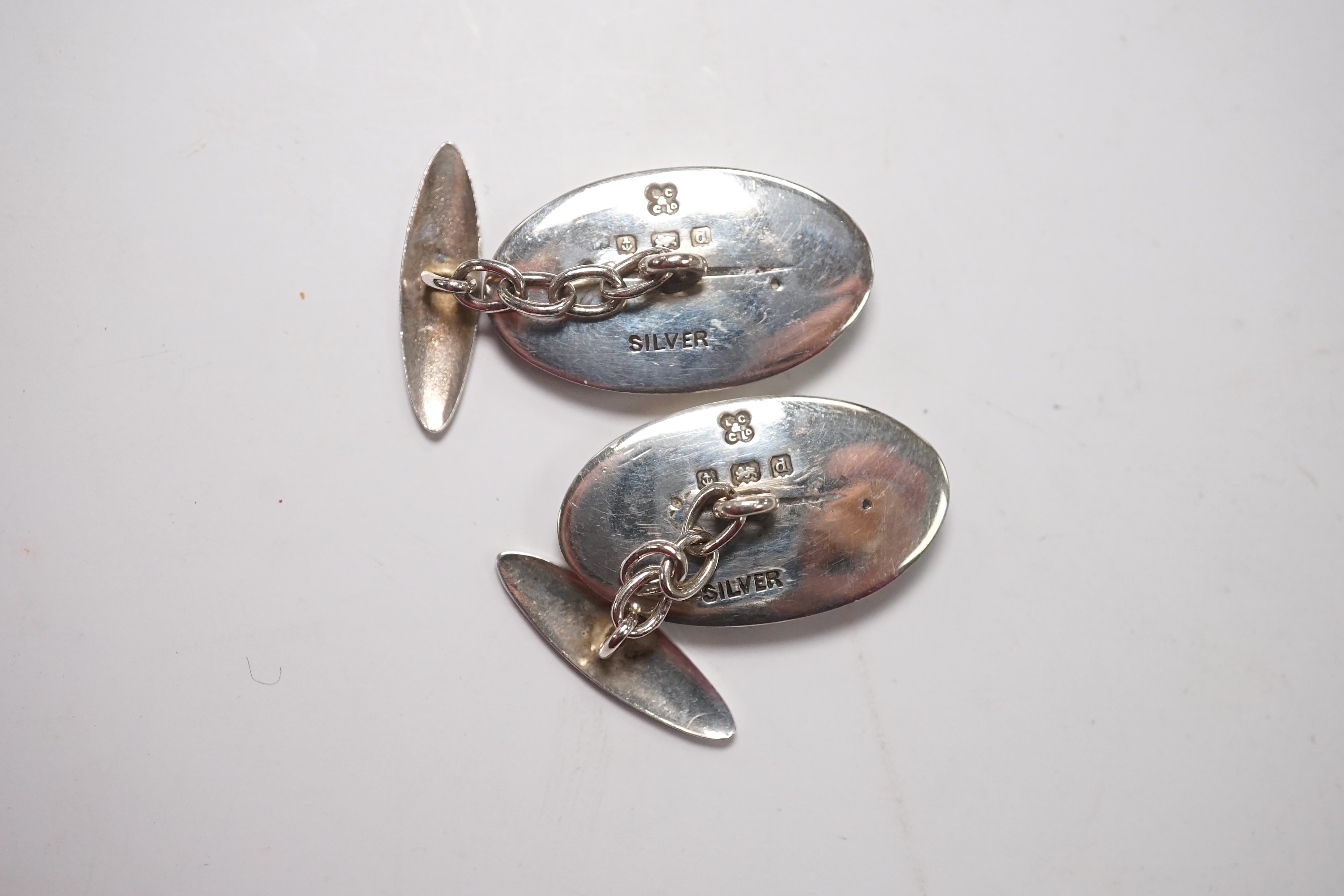 A pair of Edwardian Art Nouveau silver and enamel oval cufflinks, by Liberty & Co Ltd, 23mm, together with a garnet set bar brooch and a Hunt & Roskell box. Condition - poor to fair